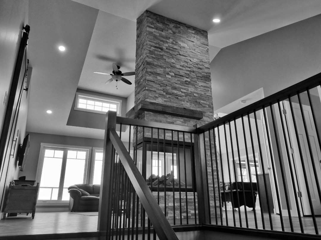 Two-storey custom lakehouse with vaulted ceilings and stacked stone fireplace